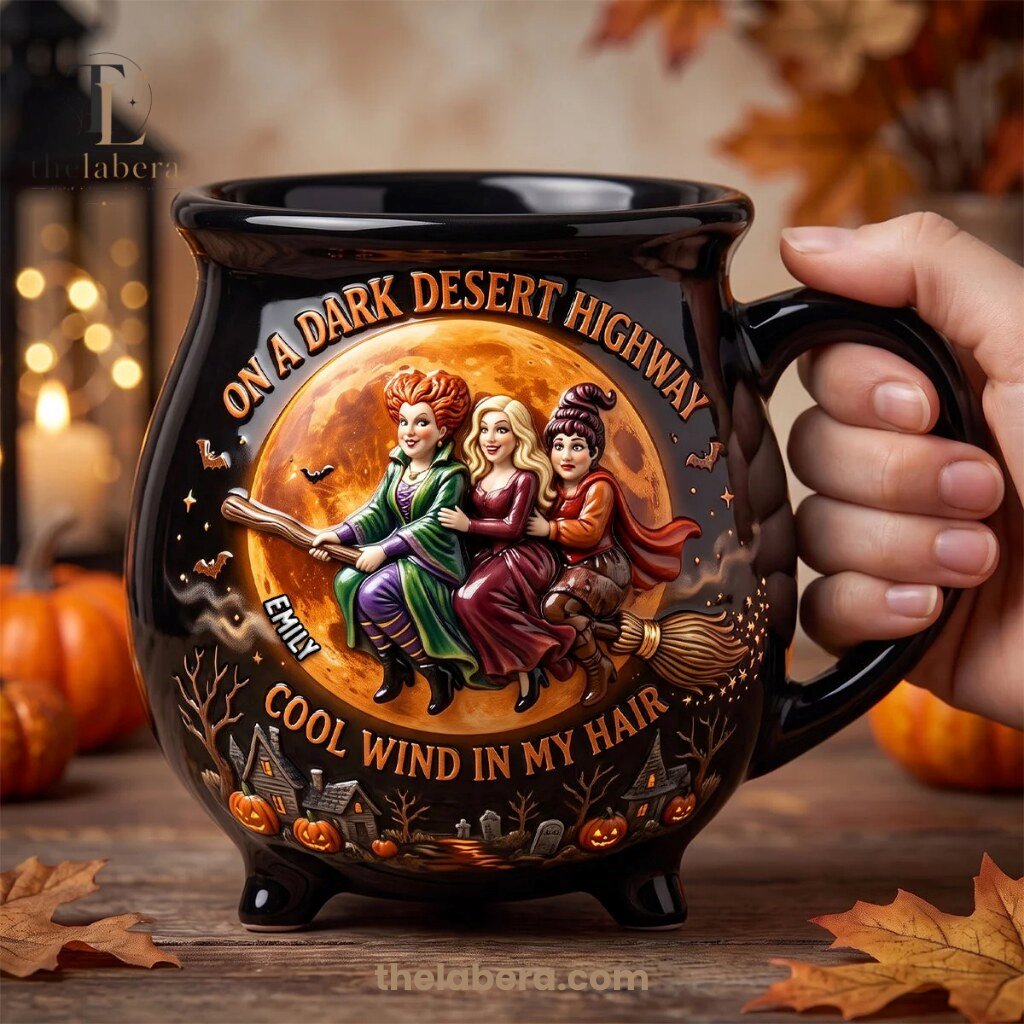 The Labera Emily Dark Desert Highway Witches Cauldron Mug Black 10 Black ceramic cauldron mug with three witches riding broomstick across golden moon, Dark Desert Highway design, personalized name Emily, jack-o-lanterns and graveyard setting